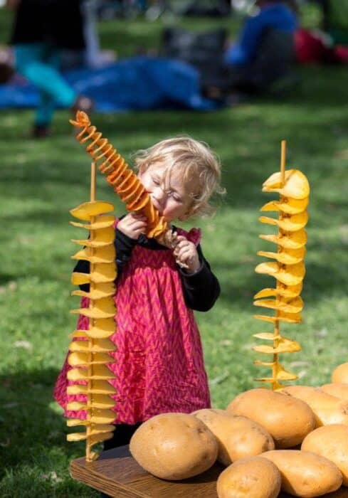 Little Girl With Potato On A Stick